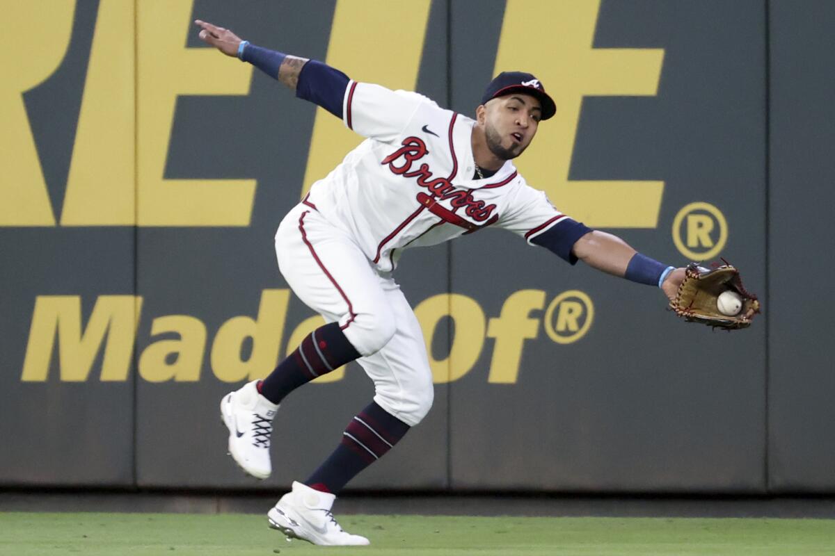 ]Atlanta Braves left fielder Eddie Rosario catches a line drive hit by Los Angeles Dodgers' Trea Turner ]