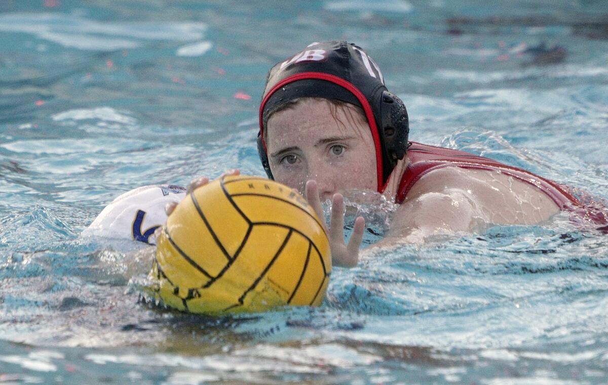 Burroughs' Bella Mucha reaches to steal the ball from Santa Ana's Sindy Gomez in the first round of the CIF Southern Section Division V girls' water polo playoffs at Burroughs High School on Tuesday, February 11, 2020. Burroughs won the game and advances.