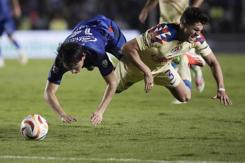 Alexis Gutiérrez, del Cruz Azul, e Israel Reyes, del América, caen al disputar el balón en el partido de ida de la final de México, el jueves 23 de mayo de 2024 (AP Foto/Eduardo Verdugo)