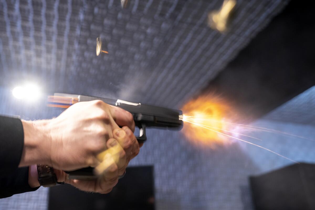 A closeup of two hands firing a pistol.