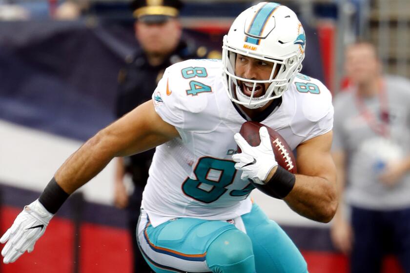 Dolphins tight end Jordan Cameron looks for running room after making a reception against the Patriots during a game earlier this season.