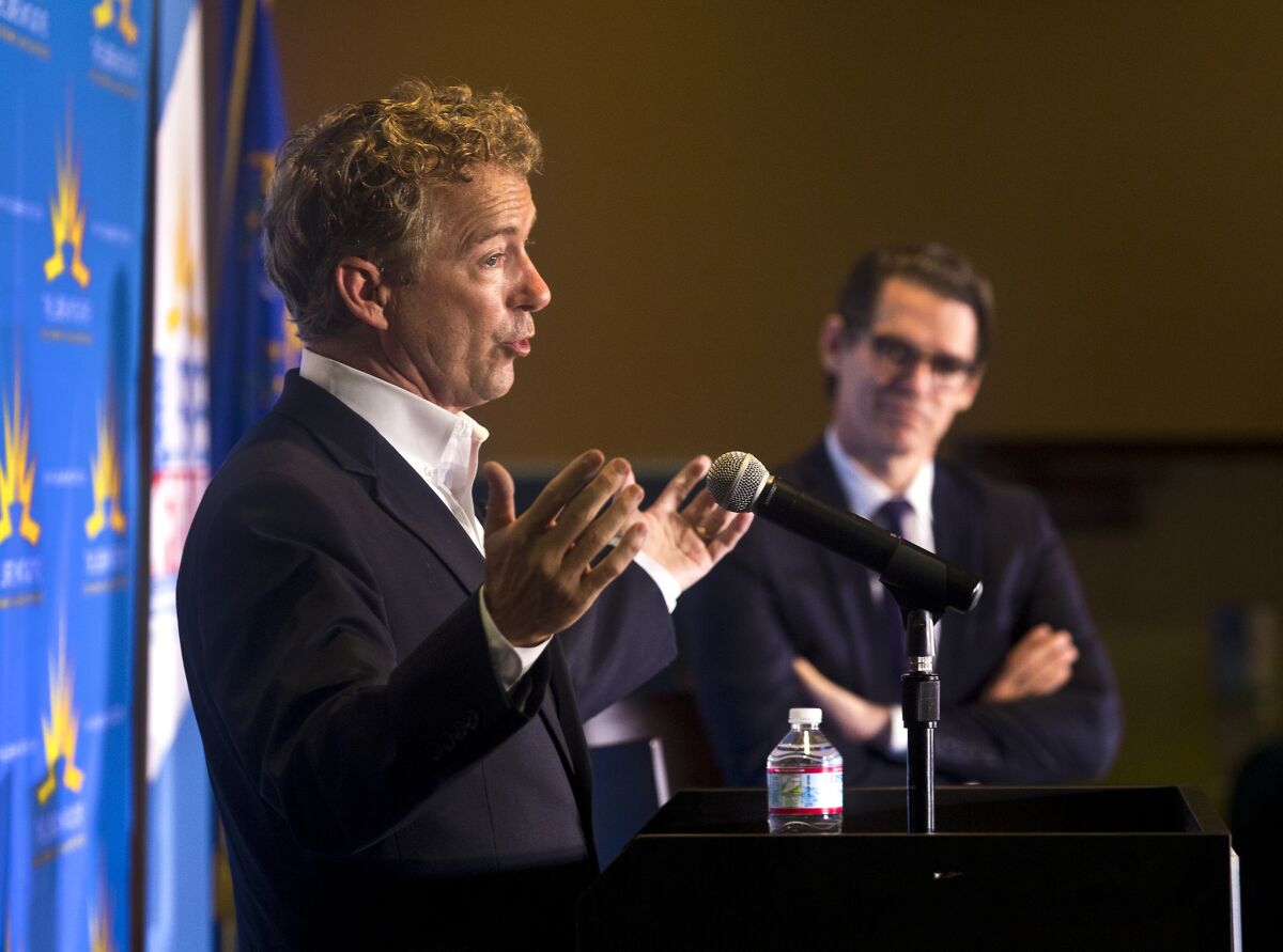 U.S. Sen. Rand Paul (R-Ky.) makes a point on stage as the Libre Initiative's executive director, Daniel Garza, listens during a speech in Las Vegas.