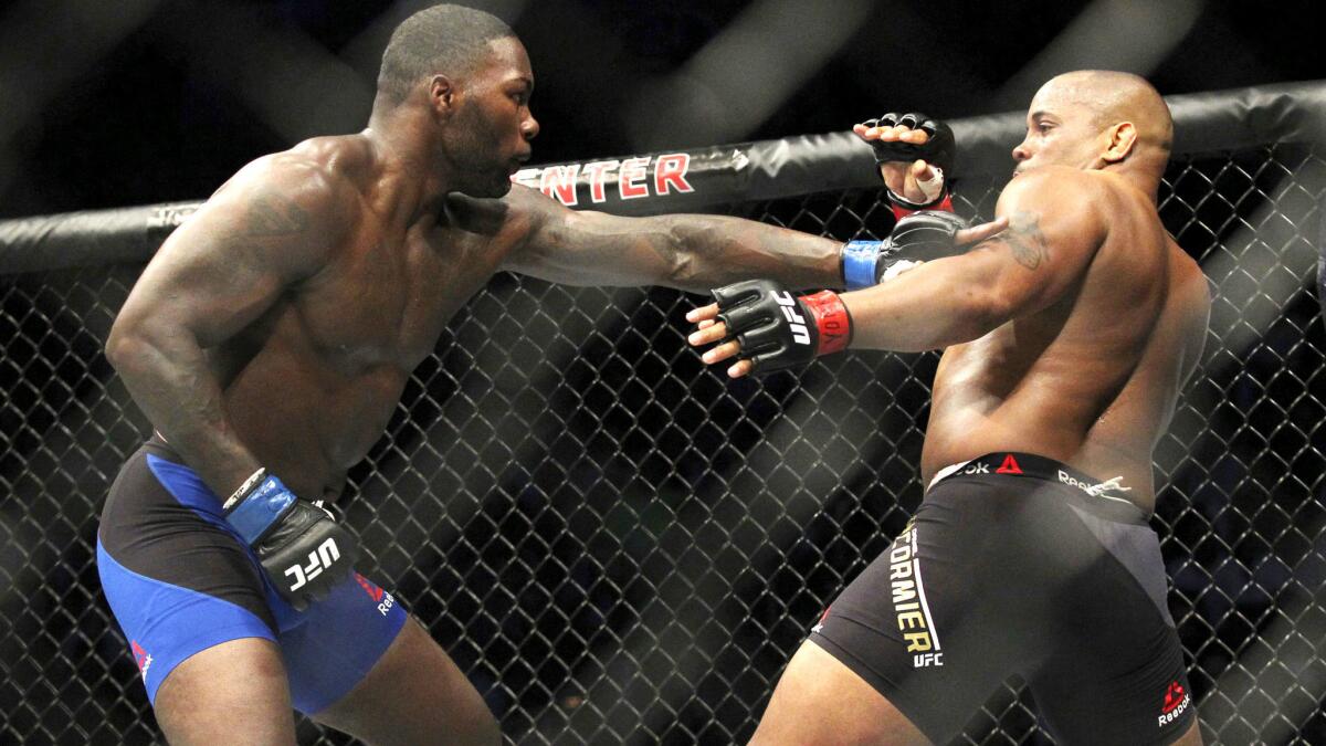 Daniel Cormier, right, tries to avoid a punch from Anthony Johnson during their light-heavyweight title fight at UFC 210.