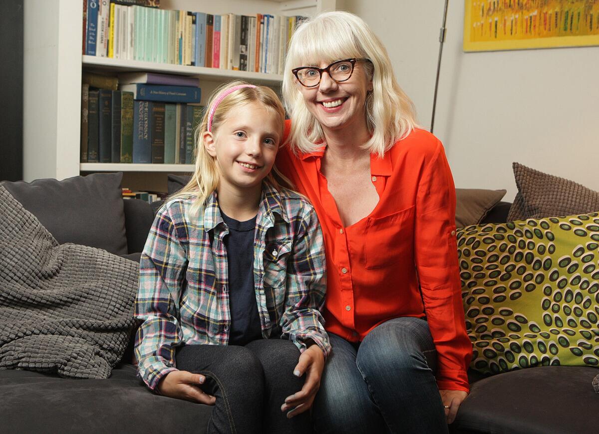 Emilia Magill, 9, with her mother Catherine Connors in their home in La Crescenta on Friday, October 16, 2015. Connors wrote the I Am A Girl book, published by TwigTale, a book that can be customized to make a personal edition to share with daughters.