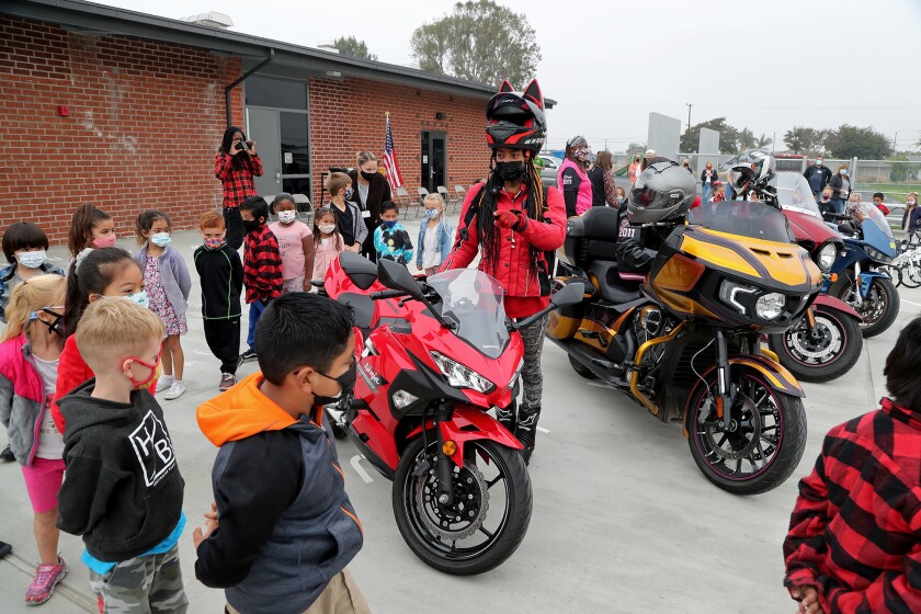 Lashaunda Malone with Black Girls Ride speaks to kindergarten students as they look at motorcycles on Thursday.