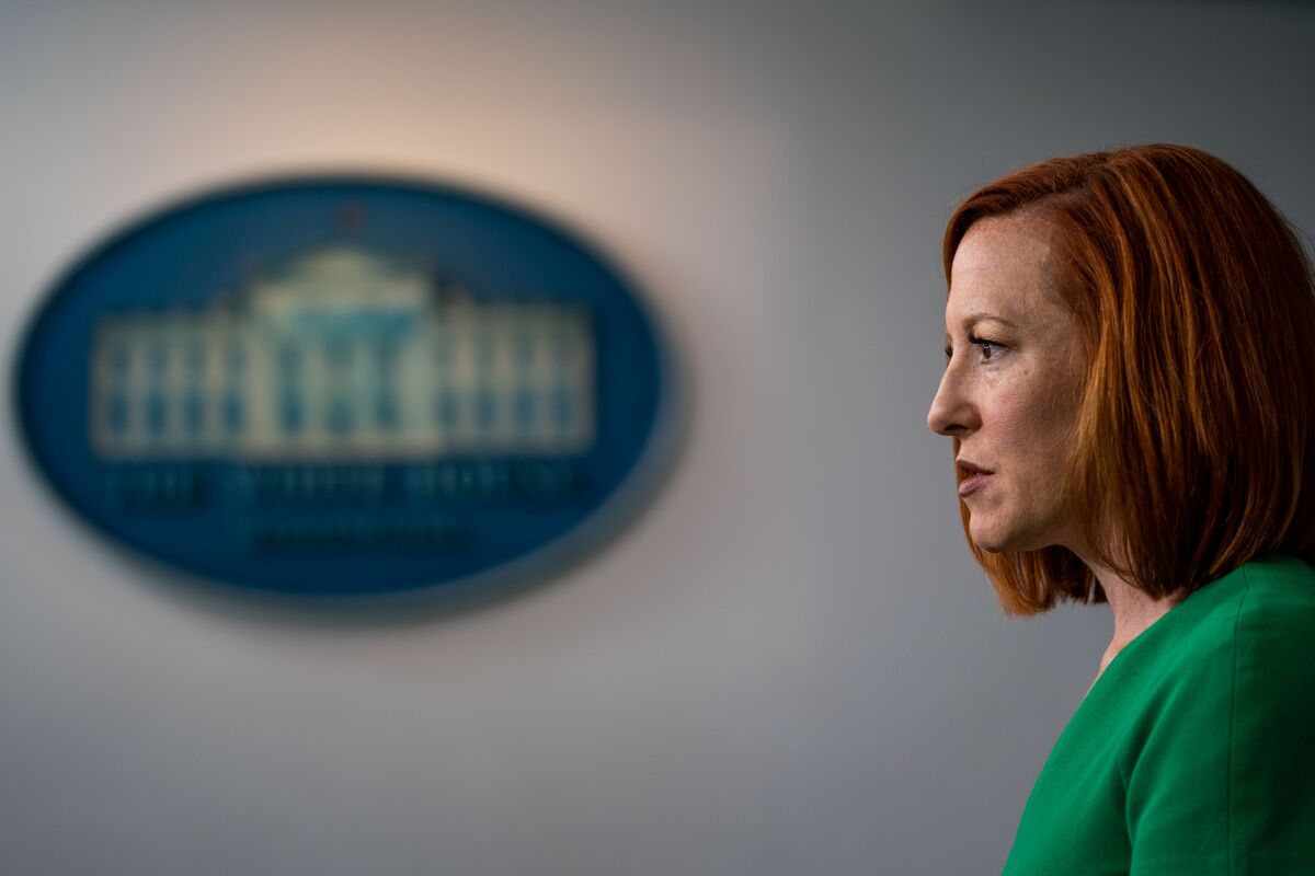 A red-haired woman in a green blouse speaks during a press briefing at the White House in 2021.