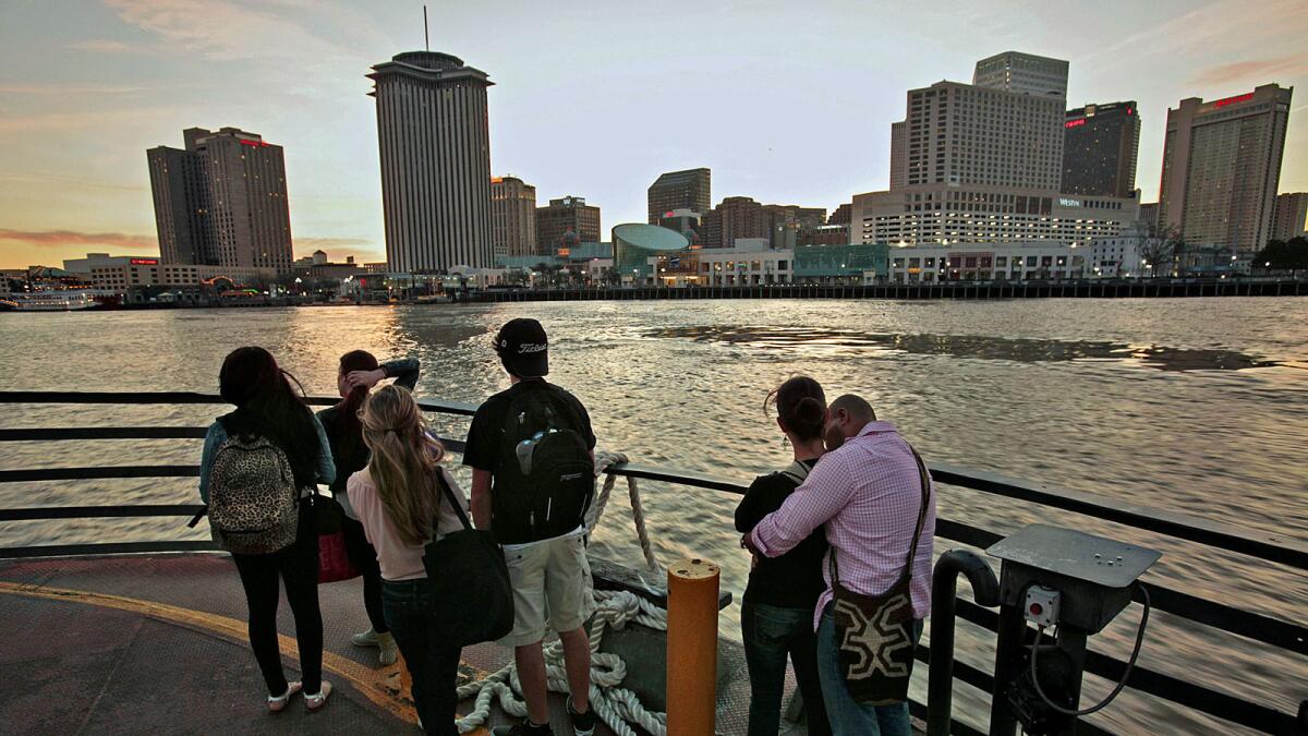 From Algiers Point, people gaze across the Mississippi River at the New Orleans skyline.