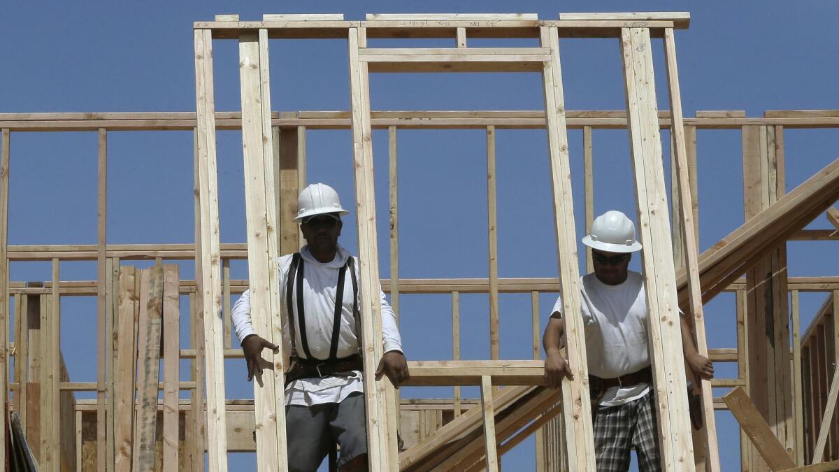 Workers raise the frame of a house under construction near Roseville, Calif.