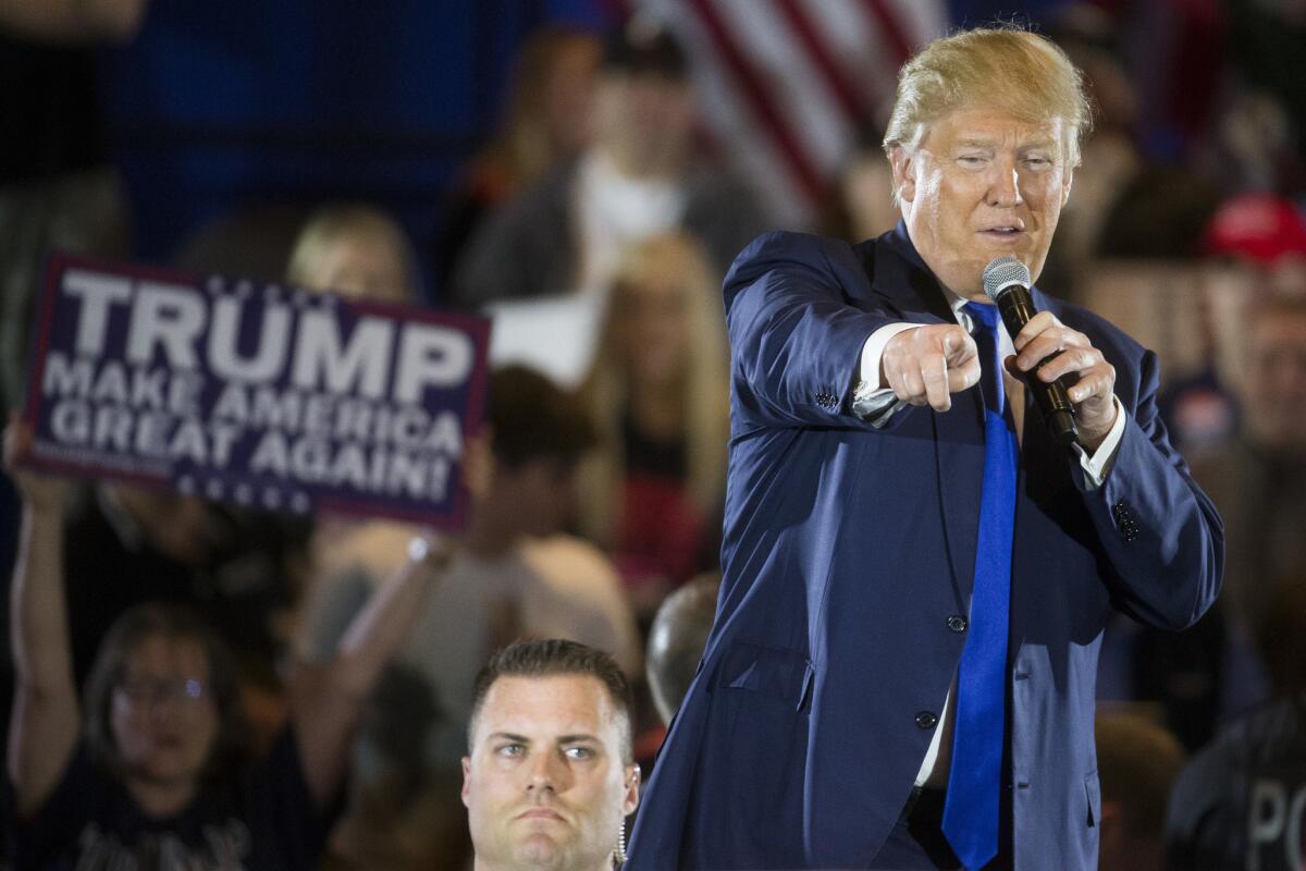 Republican presidential candidate Donald Trump speaks alongside a member of the Secret Service during a campaign stop on March 13 in West Chester, Ohio.