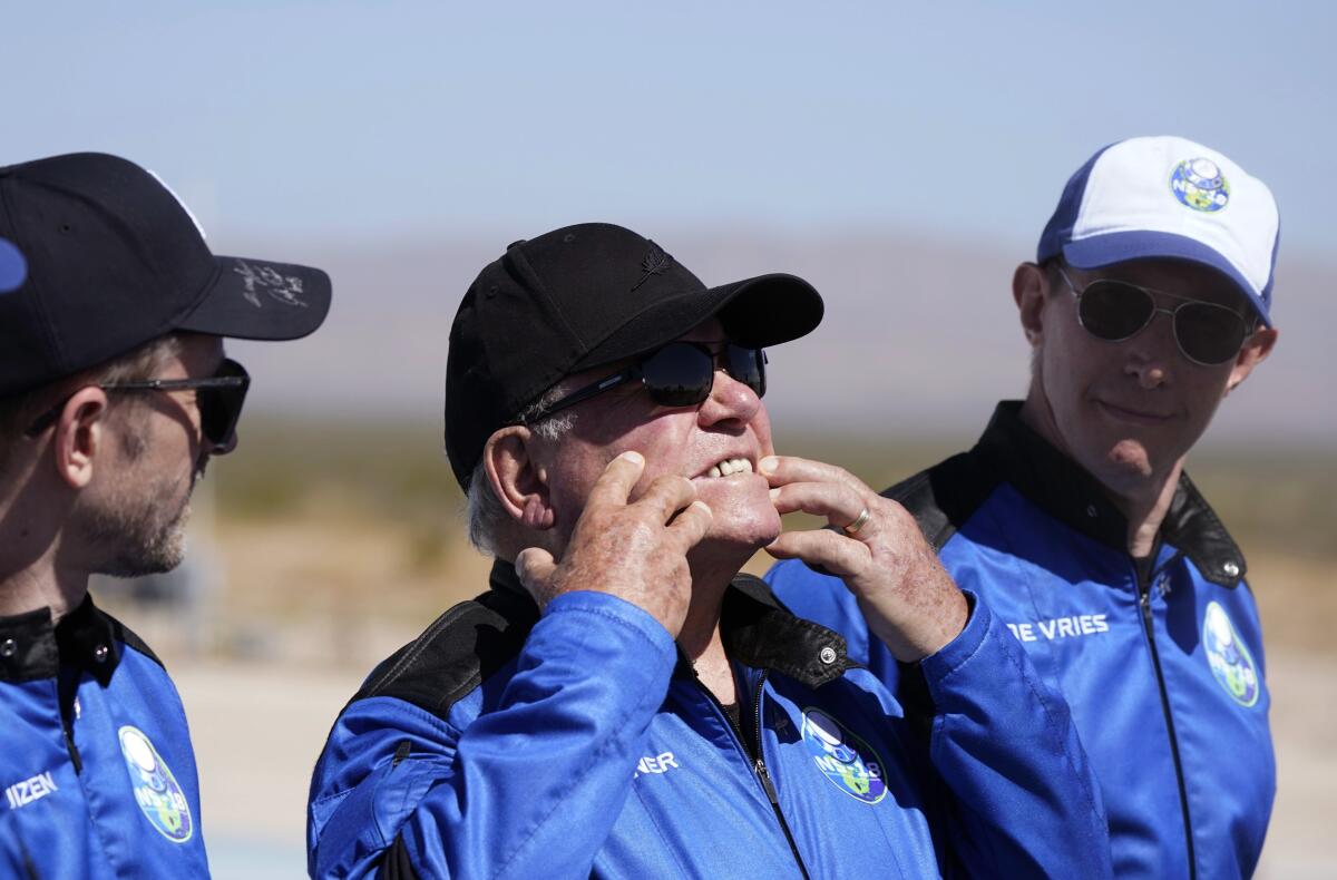 William Shatner, center, fields media questions after his flight on Blue Orgin.