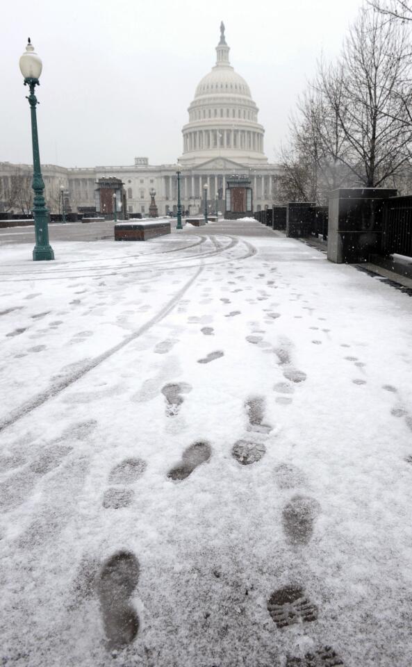 Footprints in the snow lead to the Capitol building.