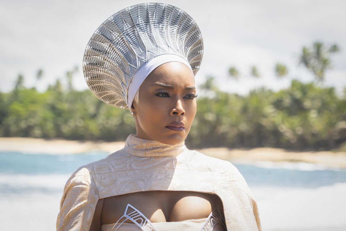 A woman in white clothing and futuristic headwear looks serious in "Black Panther: Wakanda Forever."