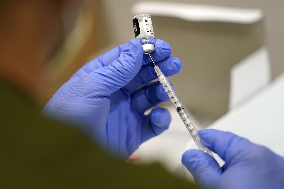 FILE - A healthcare worker fills a syringe with the Pfizer COVID-19 vaccine at Jackson Memorial Hospital, Oct. 5, 2021, in Miami. The Air Force became the second military service to approve religious exemptions to the mandatory COVID-19 vaccine, granting requests from nine airmen to avoid the shots, officials said Tuesday, Feb. 8, 2022. (AP Photo/Lynne Sladky, File)