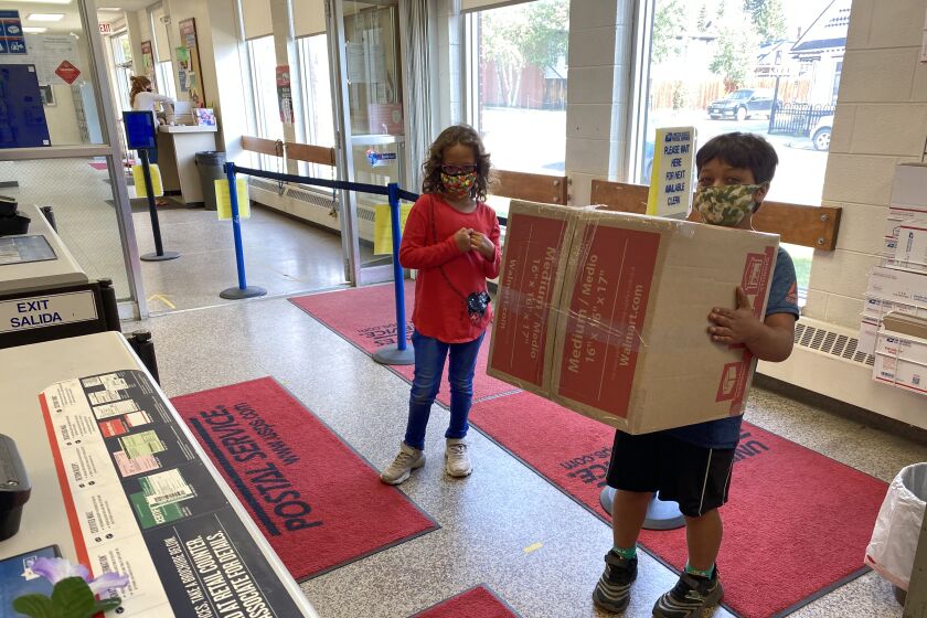 Young customers wait to mail a package Aug. 20 at the Leadville, Colo., post office.
