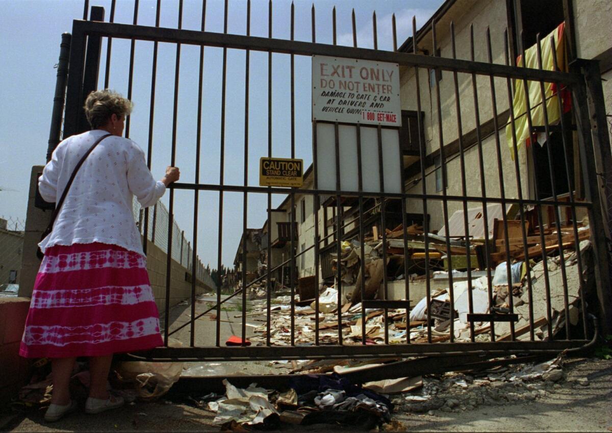 File Photo: Catherine Scott of Burbank stares at the earthquake devastated Northridge Meadows Apartments on Sunday afternoon. She said she had heard so much about the damage since the Jan. 17. earthquake that she felt compelled to see it for herself.