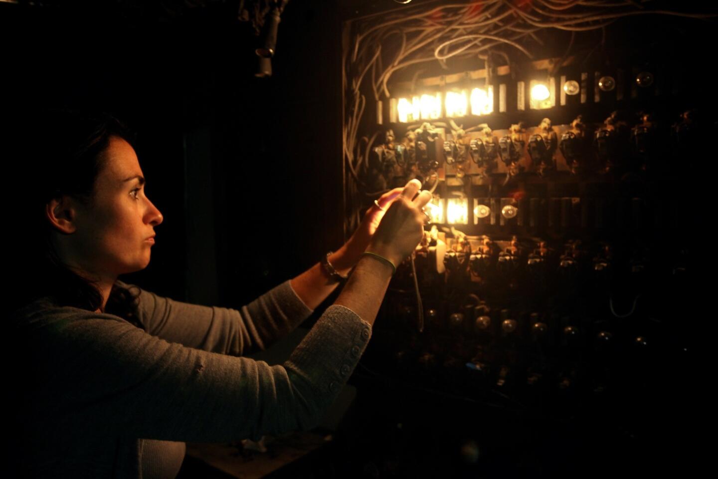 Sandi Hemmerlein of the Los Angeles Historic Theatre Foundation takes a picture of the Tower theater's lighting board, used to control the house and stage lights, in the projection booth.