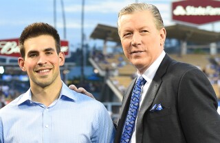 Los locutores de los Dodgers Joe Davis y Orel Hersheiser posan juntos en el campo antes de un partido contra los Gigantes de San Francisco en septiembre de 2016.