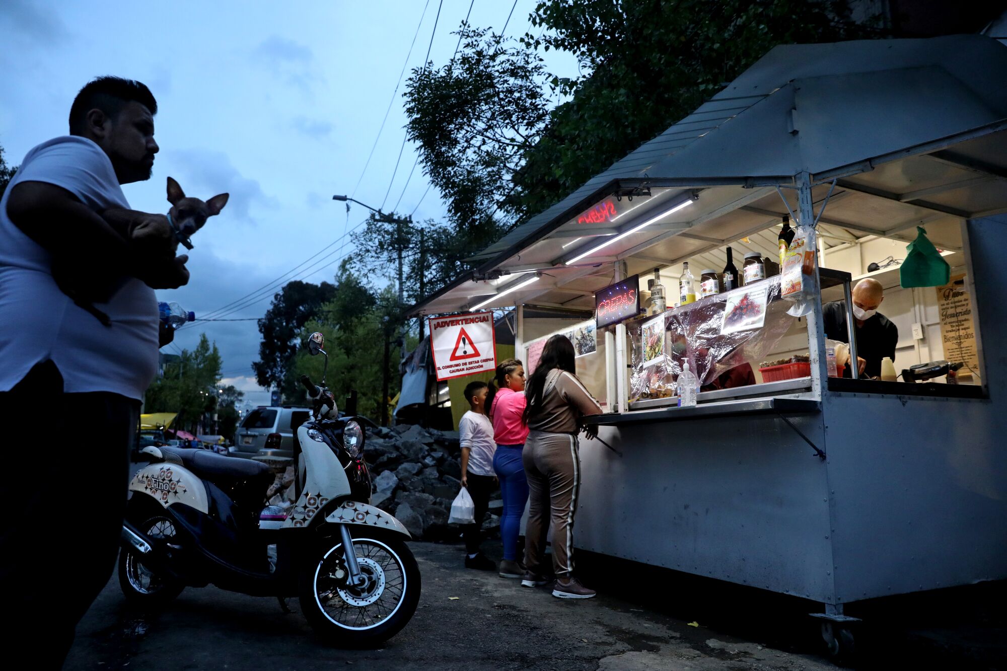 Customers wait for their order at Mexico City's Crepas El Mana, where wrestler Joel Bernal Galicia works with his wife.