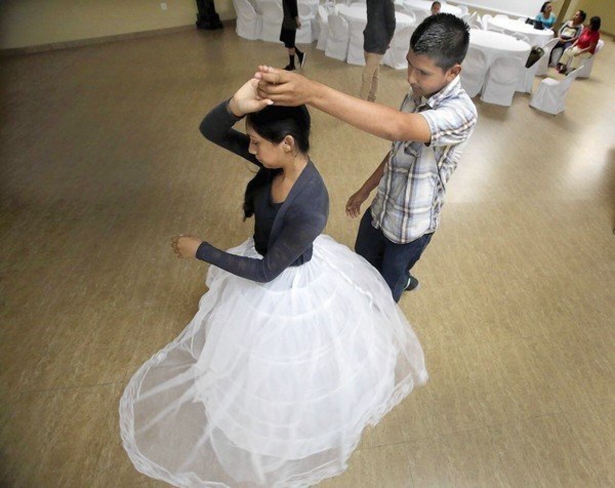 Jorge Reyes, 15, rehearses with Elvia Renteria for her upcoming quinceañera celebration. Elvia is paying Jorge to dance with her, rather than having a friend or cousin be her main escort, because she wants the peace of mind that comes with having an escort who feels confident on the dance floor.