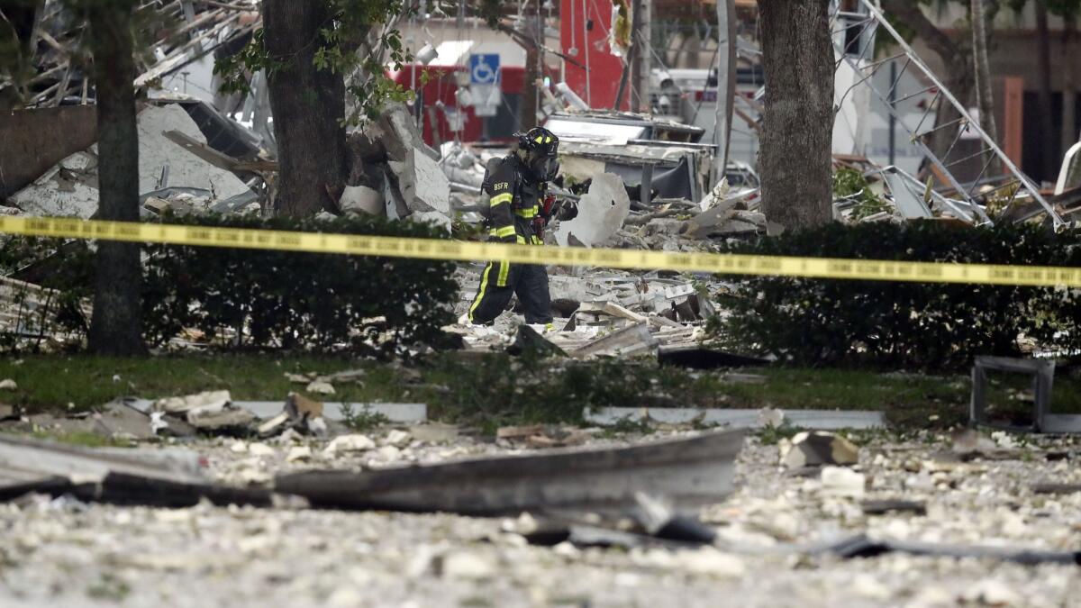 A firefighter walks through the remains of a building after an explosion July 6 in a vacant pizza restaurant in Plantation, Fla.