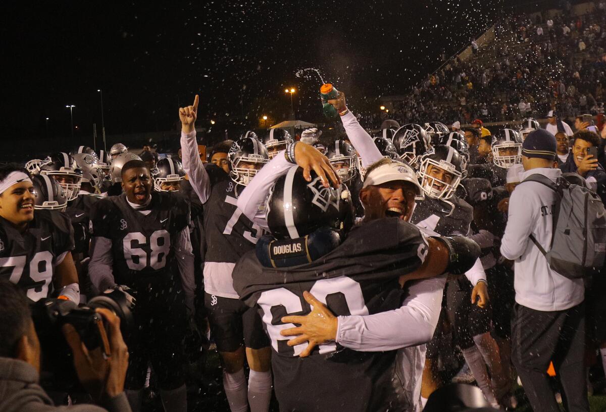 St. John Bosco High coach Jason Negro hugs Drake Metcalf as the team celebrates its CIF state championship in 2019.