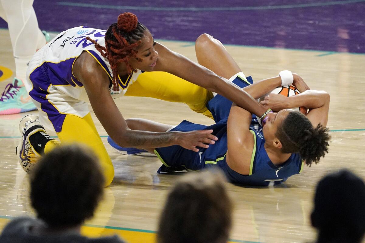 Sparks guard Bria Holmes and Minnesota Lynx guard Layshia Clarendon battle for the ball.