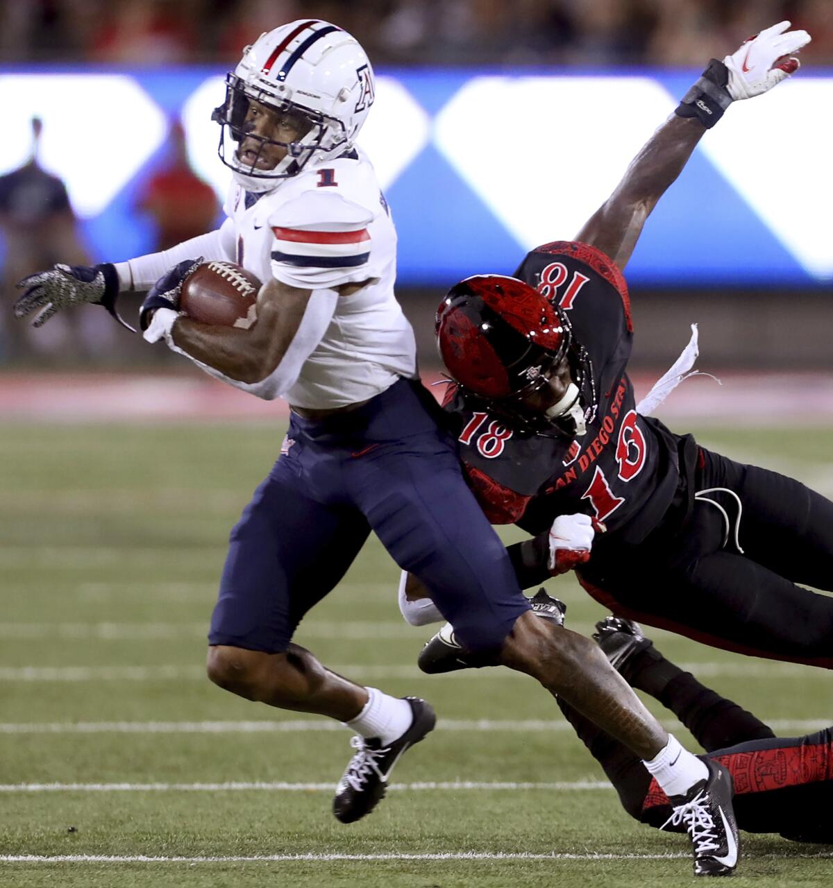 Arizona receiver Stanley Berryhill III bounces off San Diego State safety Trenton Thompson (18) after his catch and heads for the end zone for a touchdown during the first half of an NCAA college football game Saturday, Sept. 11, 2021, in Tucson, Ariz. (Kelly Presnell/Arizona Daily Star via AP)