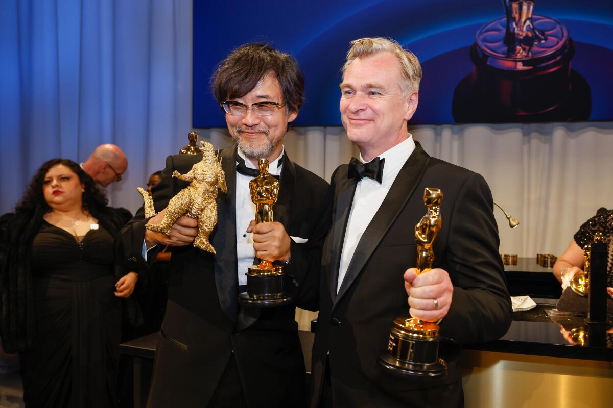 Two men with Oscars smile for the camera.