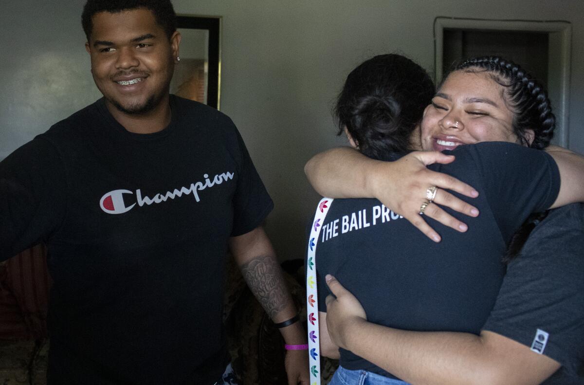 Katherine Cordova, right, hugs Bail Project's Priscilia Martinez after delivering supplies to Tomajae Tolliver.