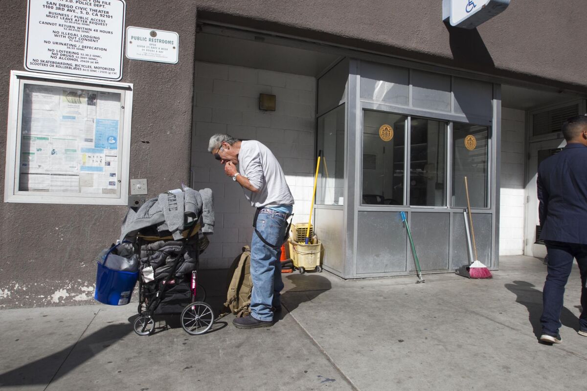 A man waits to use a public restroom on C Street in Downtown San Diego in this 2019 file photo.