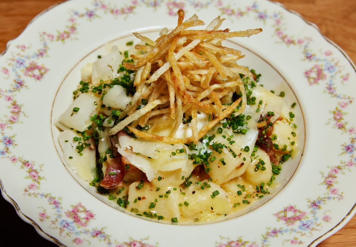 A plate filled with gnocchi, with crispy potatoes on top.