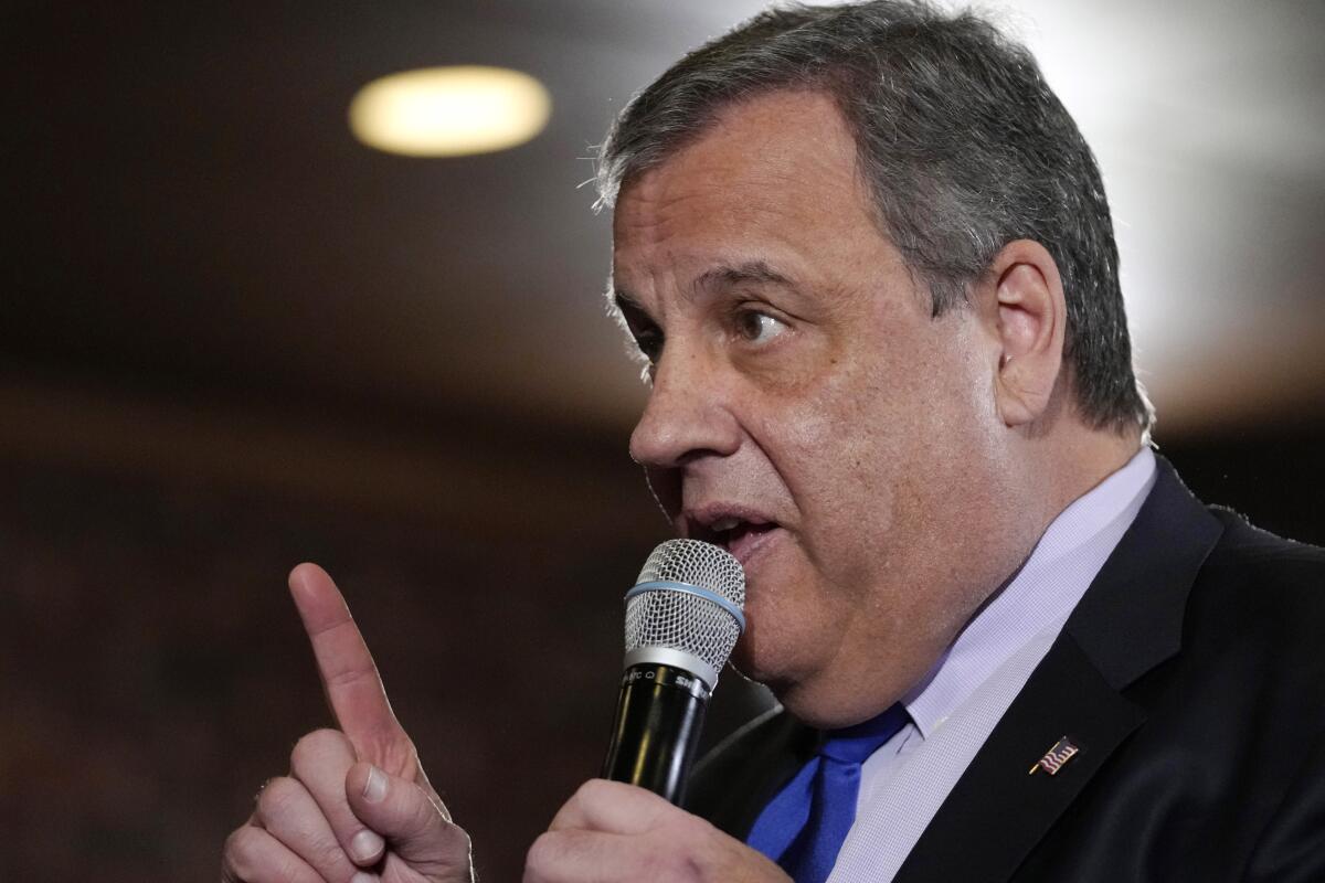 Chris Christie holds up an index finger as he speaks into a microphone