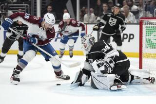 Colorado Avalanche left wing Miles Wood, left, tries to get a shot past Los Angeles Kings.