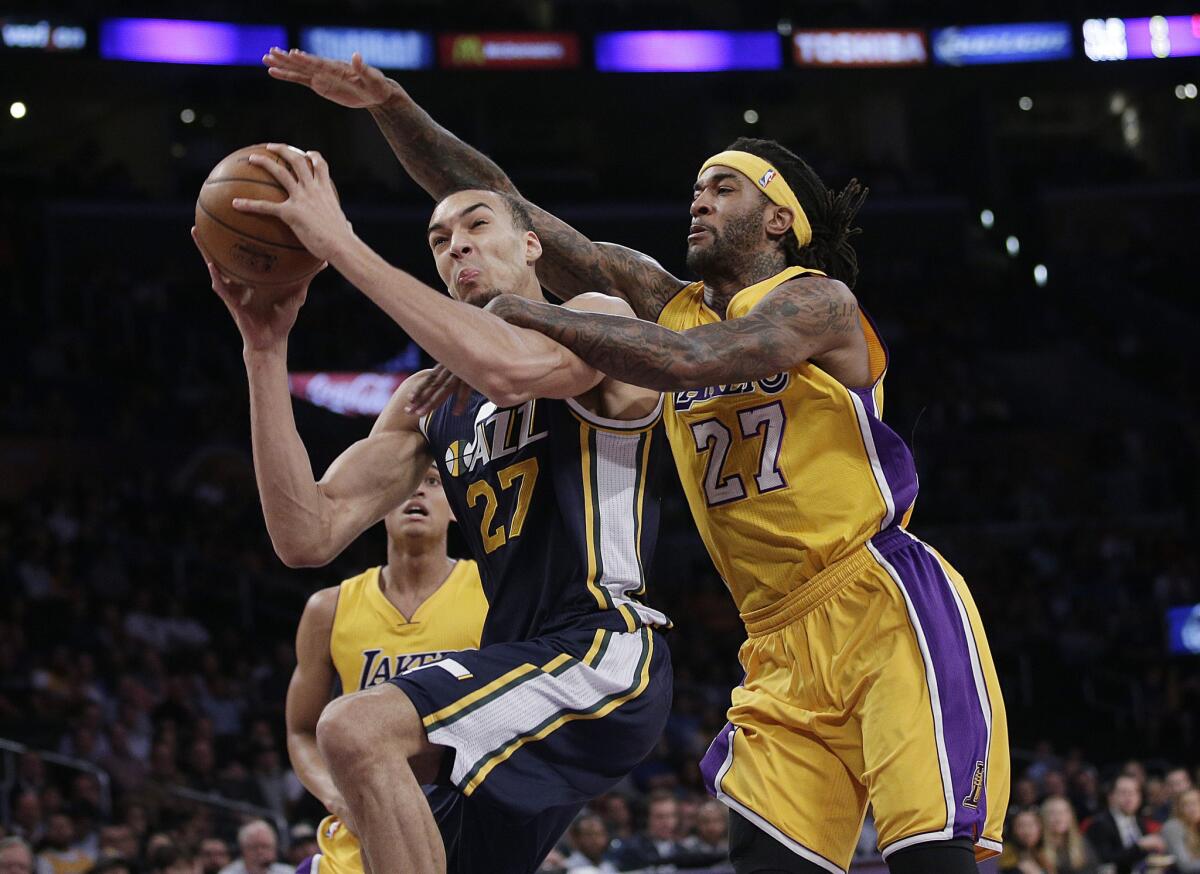 Lakers center Jordan Hill fouls Jazz center Rudy Gobert on a drive to the basket in the first half.