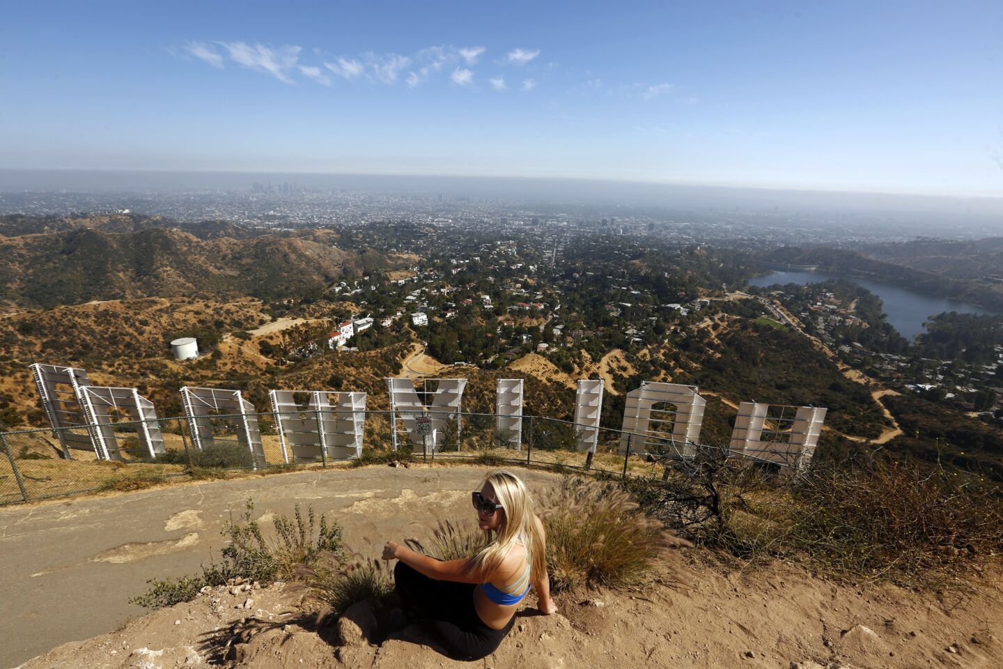 Rachelle Foos of Denver takes in the view from the top of the Mt. Lee Trail behind the Hollywood Sign in Griffith Park. Warner Bros. studio has told city officials it would foot the bill for an aerial tramway to transport visitors to and from the Hollywood sign, starting from a parking structure next to its Burbank lot.