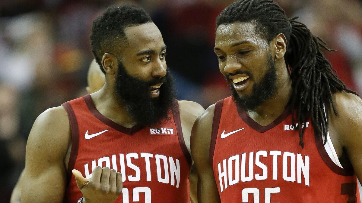 Rockets guard James Harden (13) talks with forward Kenneth Faried late in the second half of a game against the Raptors on Friday.