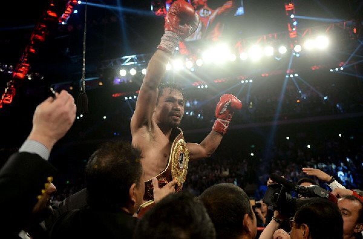Manny Pacquiao celebrates after defeating Brandon Rios by unanimous decision in their welterweight fight on Sunday in Macau.