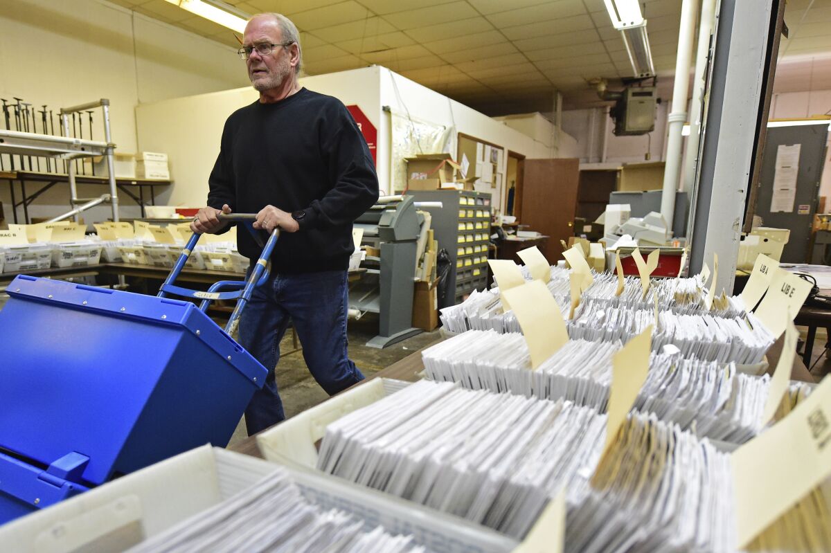 Board of Elections worker Bob Moody moves boxes of ballots at the Trumbull County Board of Elections