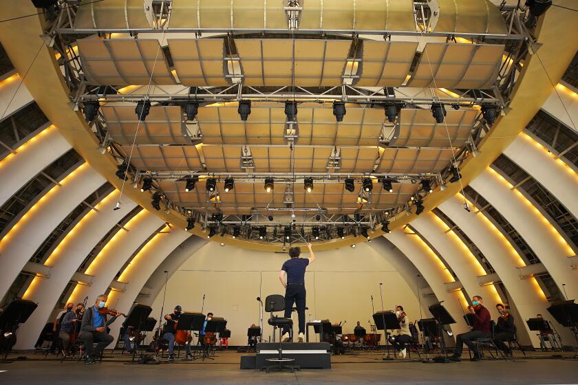 HOLLYWOOD, CA - MAY 12: Music & Artistic Director of the Los Angeles Philharmonic Gustavo Dudamel conducts the LA Phil during rehearsal May 12th at The Hollywood Bowl as the sleeping venue is rousing after 18 months of pandemic-induced hibernation. A behind-the-scenes look at what it takes, reveals a Los Angeles Philharmonic rehearsal, buzzing like never before. Hollywood Bowl on Wednesday, May 12, 2021 in Hollywood, CA. ({a} / Los Angeles Times).