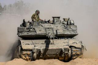 Israeli soldiers drive a tank at a staging ground near the border with the Gaza Strip, in southern Israel on May 5.