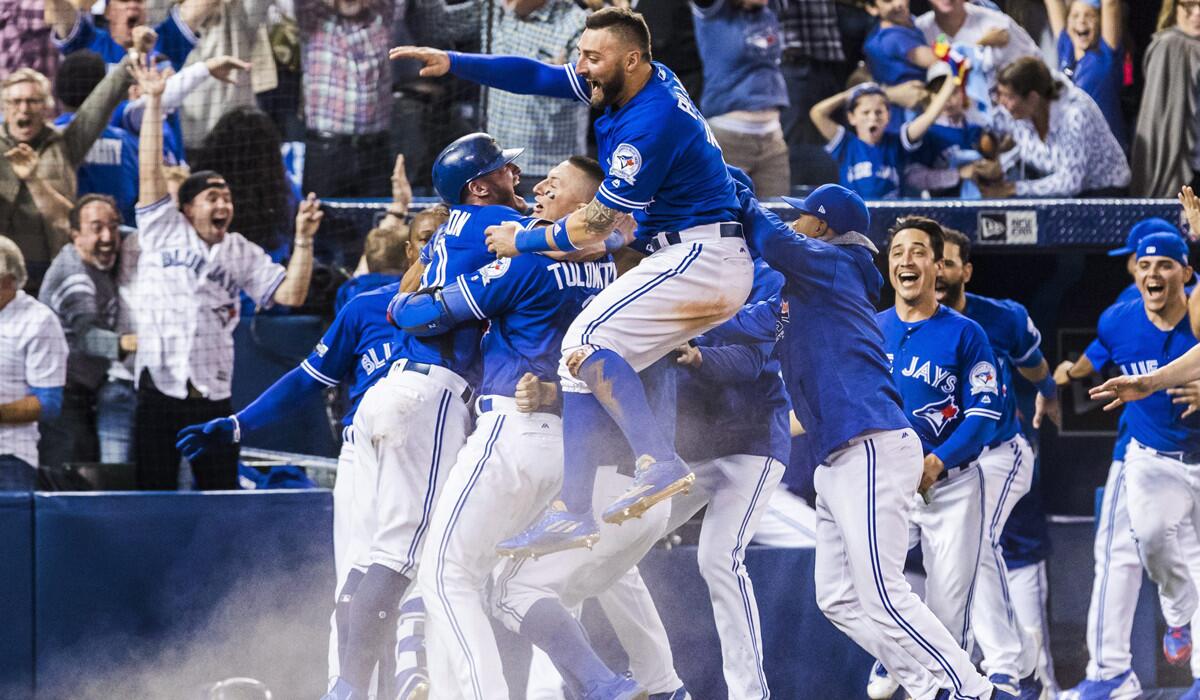 Toronto Blue Jays players celebrate their walk-off win in Game 3 to eliminate the Texas Rangers in the American League division series on Sunday.