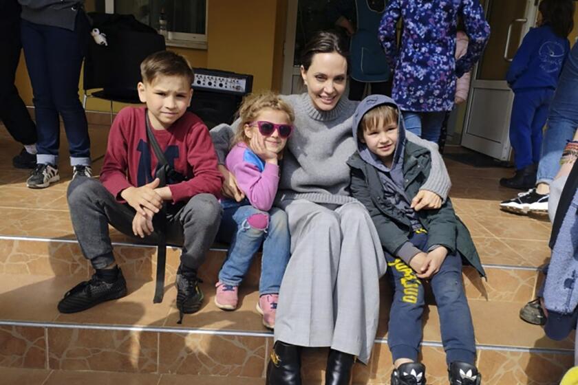 En esta imagen facilitada por el ayuntamiento de Leópolis, Angelina Jolie, actriz de Hollywood y embajadora de buena voluntad de ACNUR, posa el sábado 30 de abril de 2022 para una foto con niños en Leópolis. (Maksym Kozutsky/Ayuntamiento de Lviv vía AP)