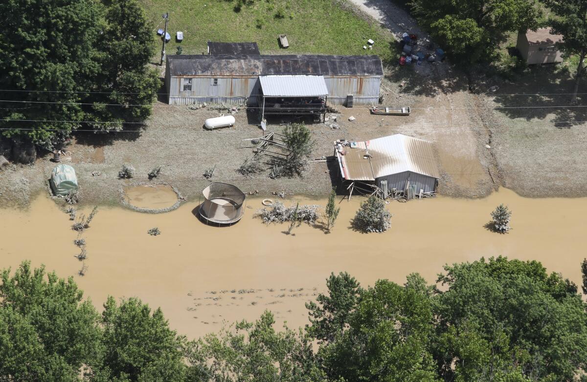 FILE - In this aerial photo, some homes in Breathitt County, Ky., are still surrounded by water Saturday, July 30, 2022, after historic rains flooded many areas of Eastern Kentucky killing multiple people. The mysterious death of a high school athlete who spent days helping his fellow eastern Kentuckians clean up from historic flooding has added a new layer of grief to the tragedy. On Wednesday, Aug. 10, Aaron “Mick” Crawford was counted as the 38th person to die as a result of flash flooding that swept away homes and swallowed communities last month in the Appalachian region. (Michael Clevenger/Courier Journal via AP, File)