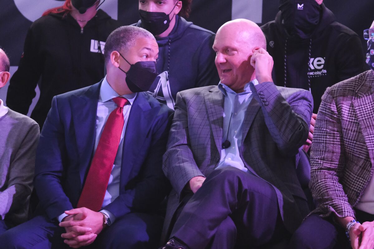 Clippers owner Steve Ballmer (unmasked) and head coach Tyronn Lue (masked) sit next to each other.