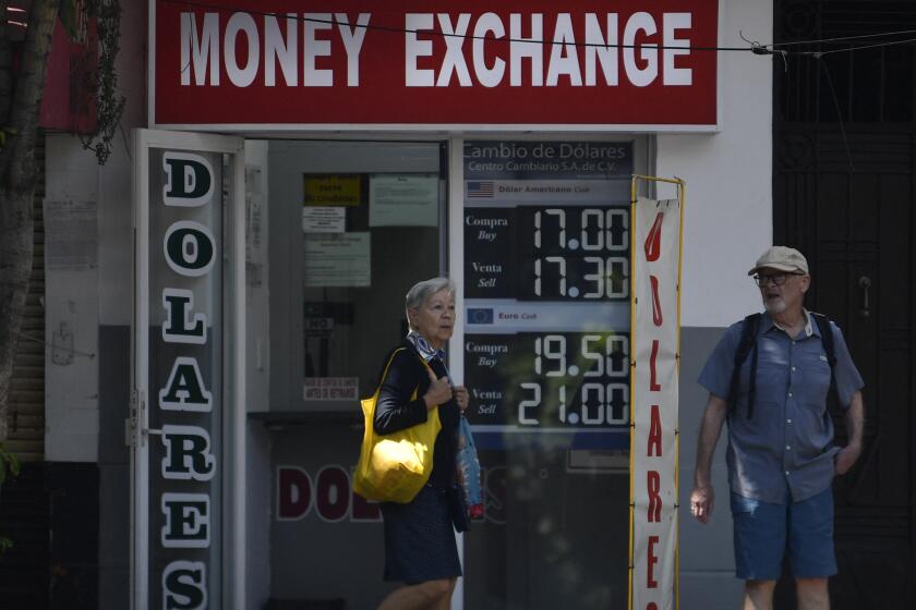A woman walks past a money exchange in Mexico City on June 23, 2023. The Mexican peso has appreciated by 13.45% against the dollar in 2023, due to factors such as a high reference rate, financial stability, massive remittance flows, and foreign investment. This appreciation has led to individuals receiving money from the United States obtaining fewer pesos when withdrawing it in Mexico due to the strength of the local currency. While it benefits importers, this situation affects 4.6 million households in Mexico that depend on remittances as their main source of foreign exchange. (Photo by CLAUDIO CRUZ / AFP) (Photo by CLAUDIO CRUZ/AFP via Getty Images)
