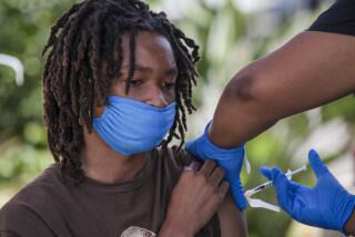 Los Angeles, CA - July 16: Jacob Alexander, 14, gets second dose of Pfizer-BioNTech vaccine at a mobile COVID-19 vaccine clinic, hosted by Mothers In Action in collaboration with L.A. County Department of Public Health at Mothers in Action on Friday, July 16, 2021 in Los Angeles, CA. (Irfan Khan / Los Angeles Times)