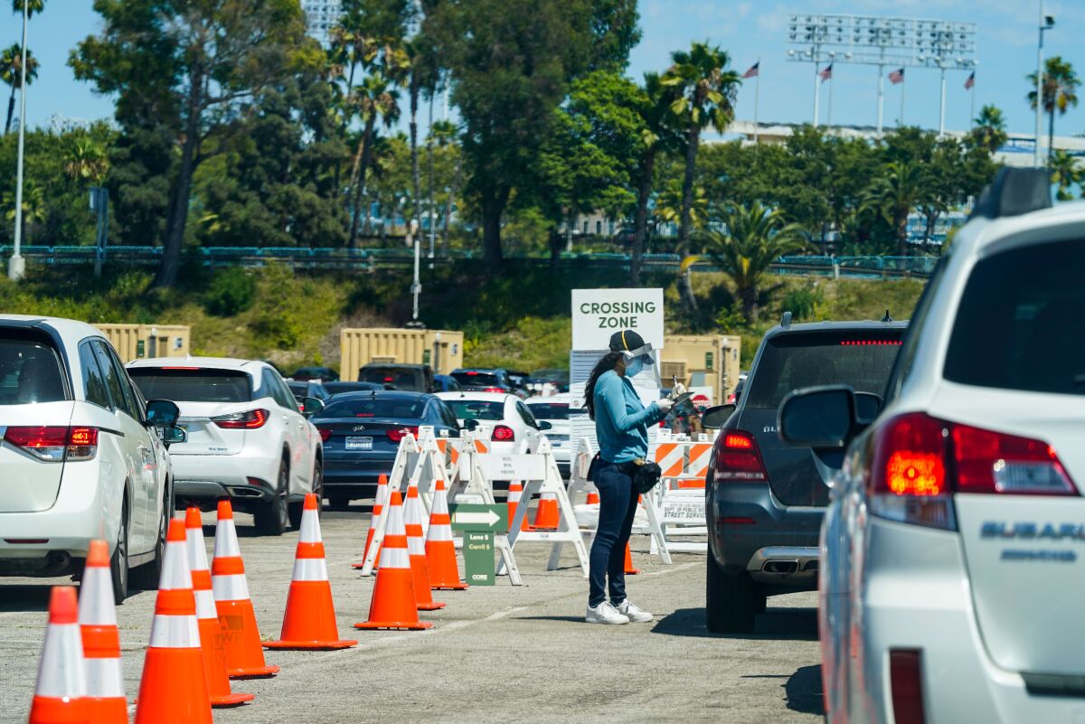 Cars line up at a COVID-19 test site at Dodger Stadium on Aug. 12 in Los Angeles.