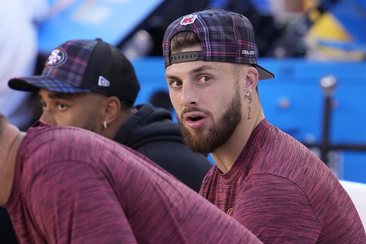 49ers wide receiver Ricky Pearsall sits on the bench in street clothes during an football game against the Patriots