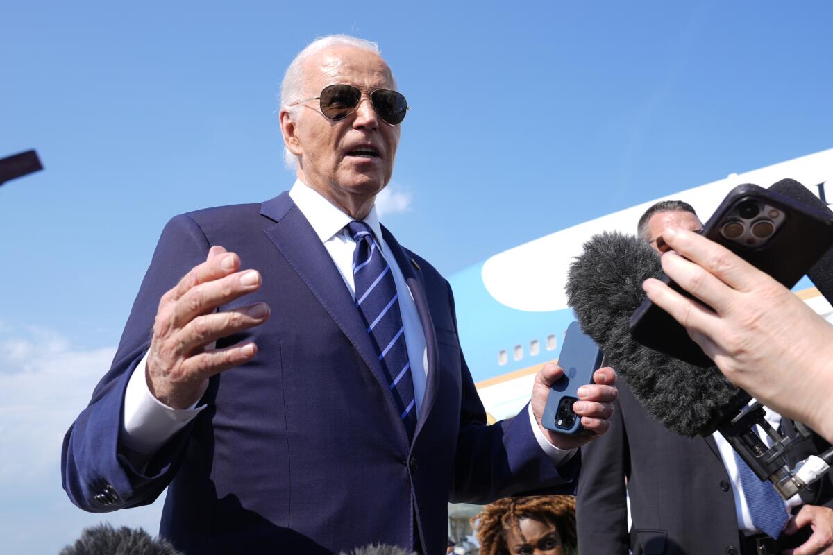 El presidente Joe Biden habla con reporteros a su llegada para abordar el avión presidencial