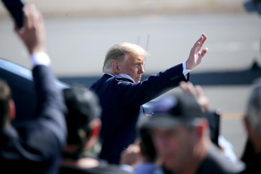 President Donald J. Trump greets supporters waiting for him on the tarmac at the John Wayne Airport, in Santa Ana on Sunday, Oct. 18, 2020. President Trump was in Orange County for a fundraiser in Newport Beach.